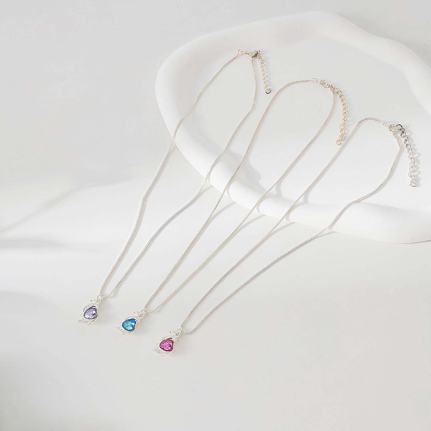 Two Dolphins surrounding Crystal Heart pendant on silvery chain Necklace