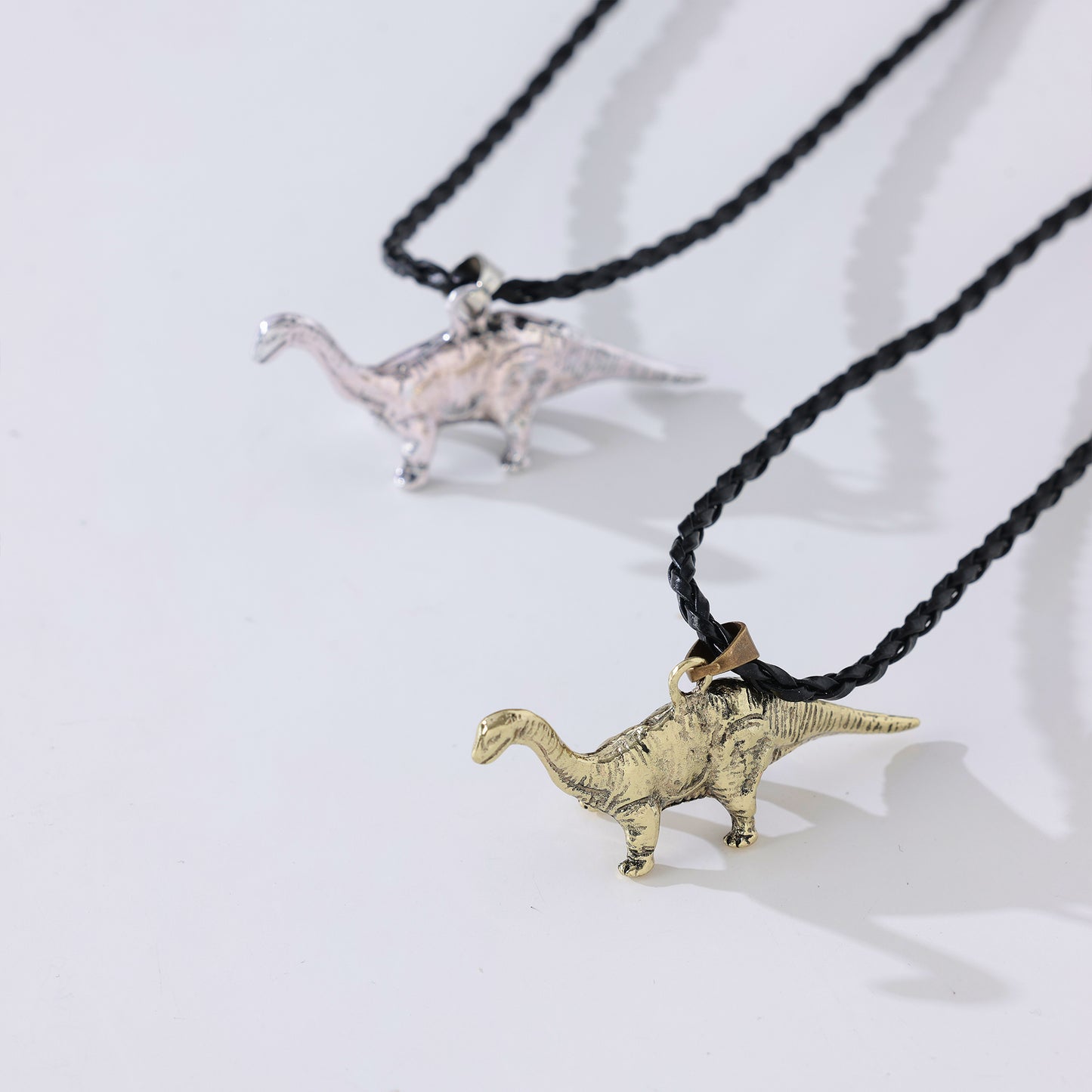 Long Neck Dinosaur Pendant Necklace – Gold-Tone & Pewter Finish, Retro Jurassic Charm on Black Woven & Waxed Cotton Cords, Unique Jewelry for Men & Women