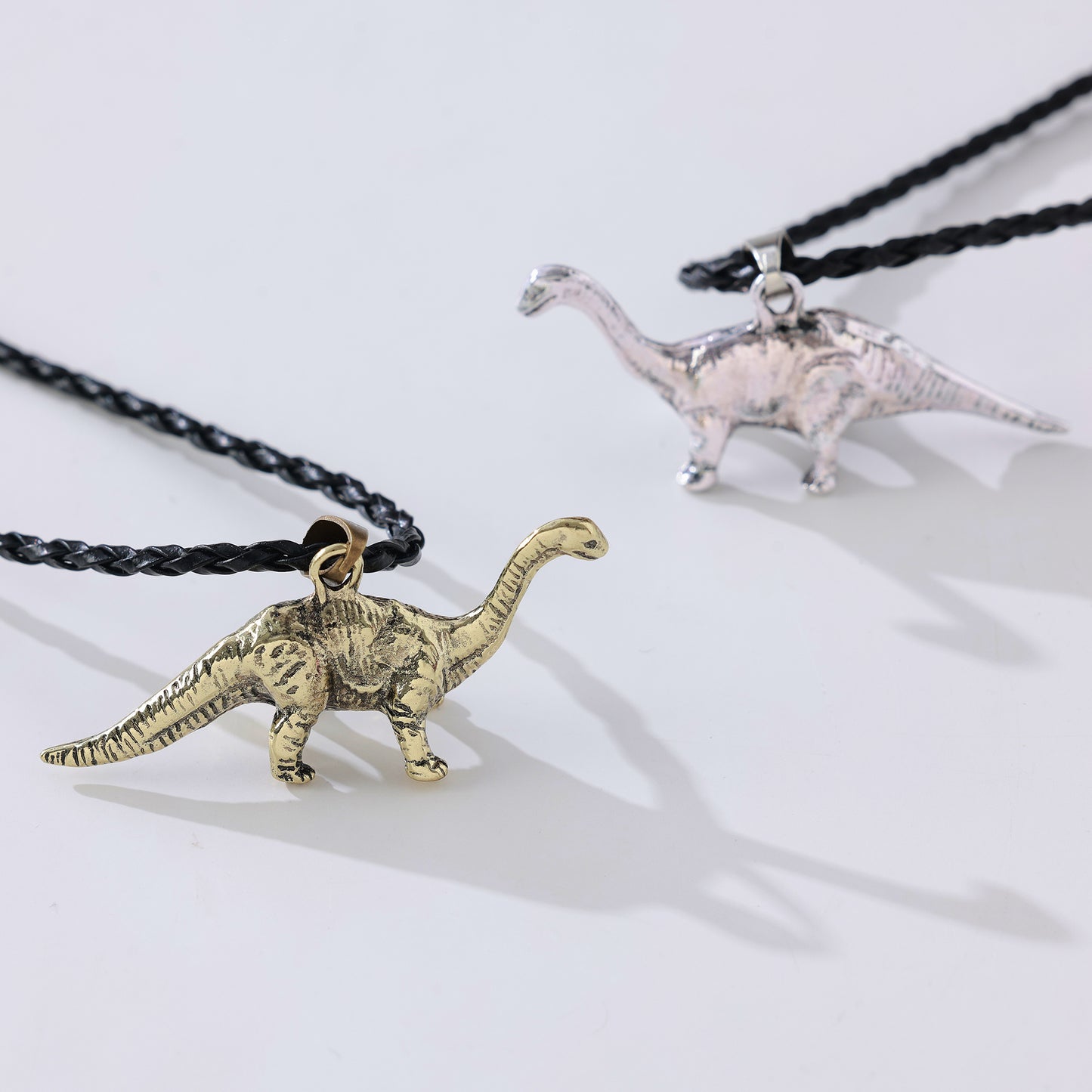 Long Neck Dinosaur Pendant Necklace – Gold-Tone & Pewter Finish, Retro Jurassic Charm on Black Woven & Waxed Cotton Cords, Unique Jewelry for Men & Women